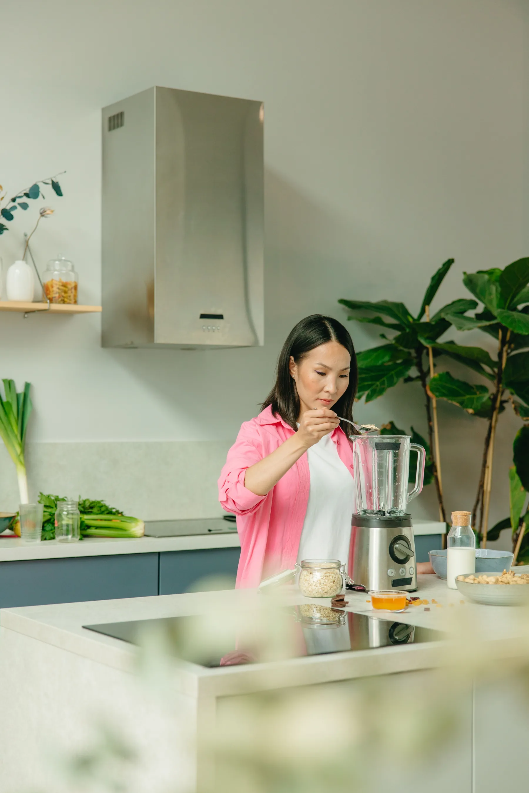 A woman preparing a nutritious smoothie in a bright kitchen