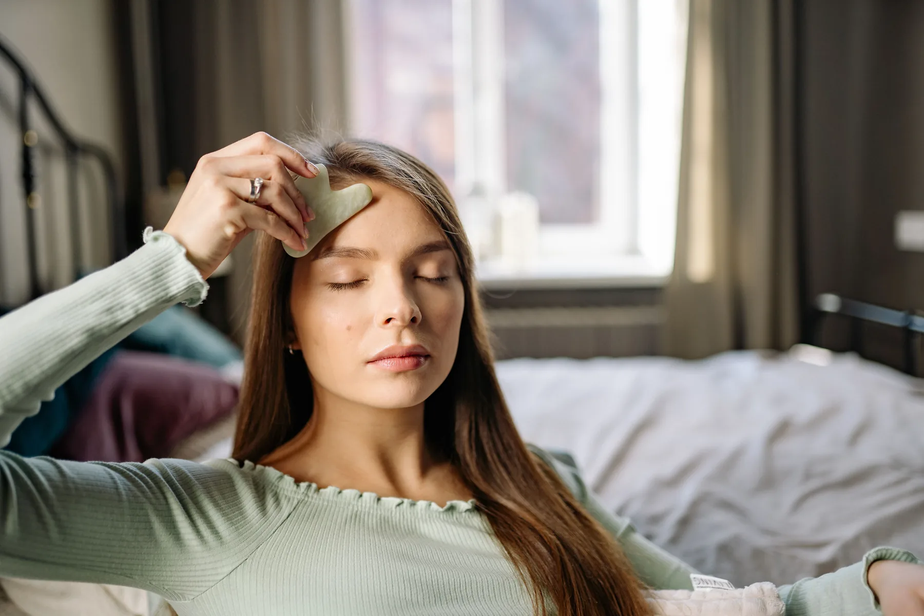 A woman enjoying a restorative facial ritual at home